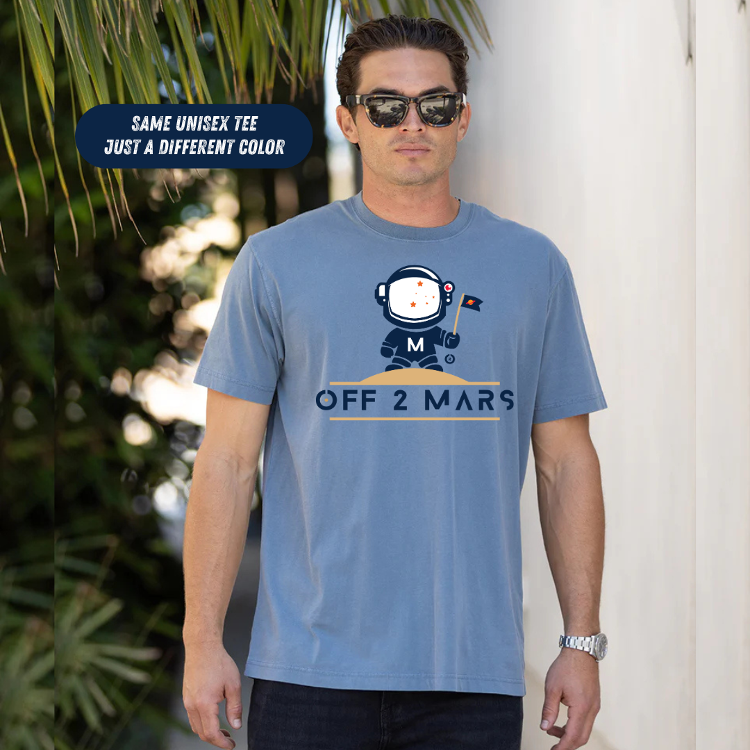 Man wearing a blue t-shirt with an astronaut graphic and text, standing outdoors.